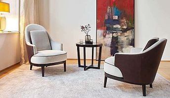 Bielefelder Werkstätten zwei Sessel Bellini bezogen mit beigem Stoff in Kombi mit einem dunkelbraunem Rücken aus Leder