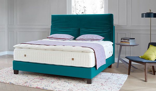 Boxspringbett Mellow von Treca in blau mit petrolfarbenen Kissen am Kopfende, OM Symbiose in Drell, Auflage Seine Prestige