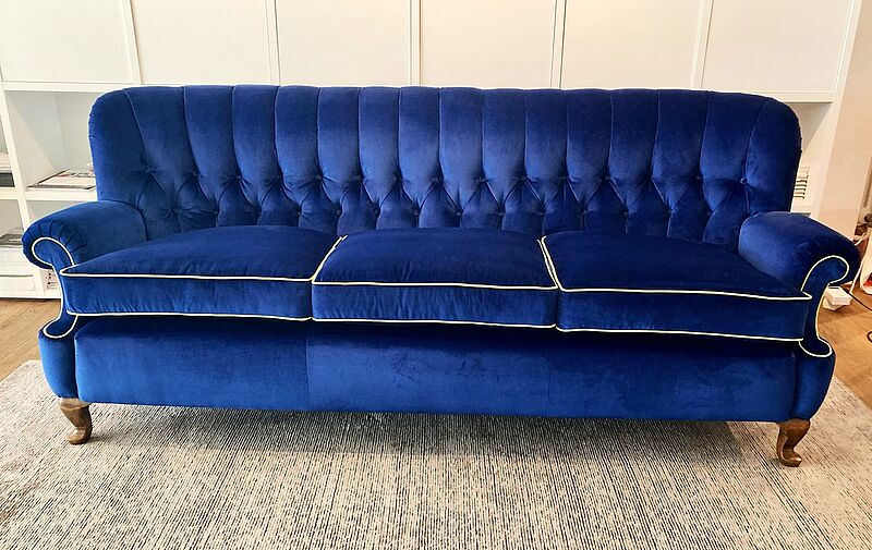 dreisitziges Sofa mit markanter Rückenheftung nach dem Neubezug. 